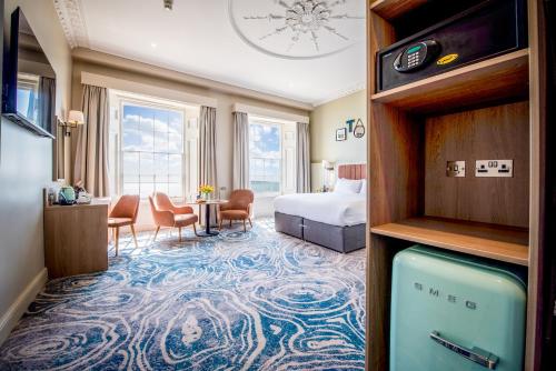 a hotel room with a bedroom with a bed and a suite at Imperial Hotel Tenby in Tenby