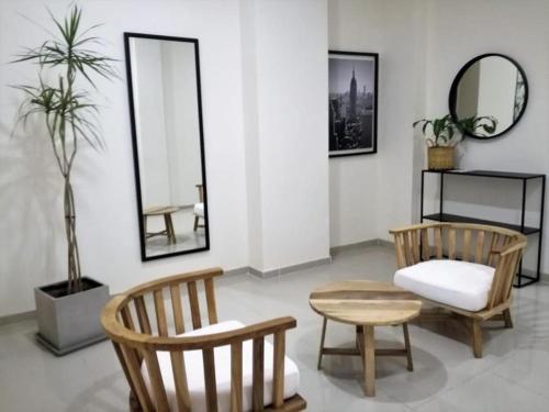 Habitación con 2 sillas, mesa y espejos en Apart del Centro 03, en Santa Fe