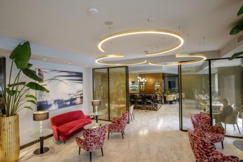 a lobby with red chairs and a dining room at Hotel St Martin by OMNIA hotels in Rome