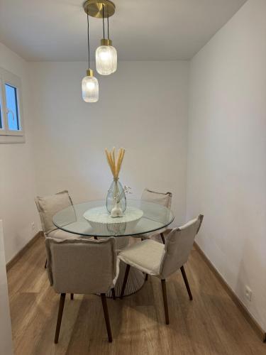 une salle à manger avec une table et des chaises en verre dans l'établissement Logement Neuf JJ appartement à La Ciotat, à La Ciotat