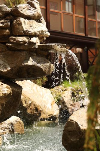 a water fountain with rocks in front of a building at СПА-Готель "RESPECT" in Skhidnitsa