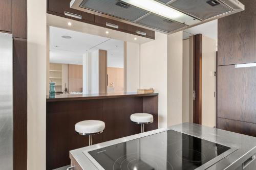 a kitchen with a counter with two stools and a mirror at Exclusive 3 Bedroom Luxury penthouse in Geneva