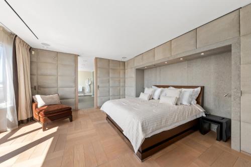a bedroom with a large bed and a chair at Exclusive 3 Bedroom Luxury penthouse in Geneva