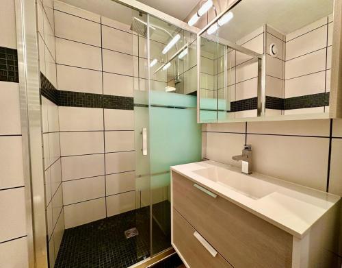 une salle de bain avec un lavabo et une douche en verre dans l'établissement appartement 4 personnes au coeur de la station des carroz d arâches, à Arâches-la-Frasse