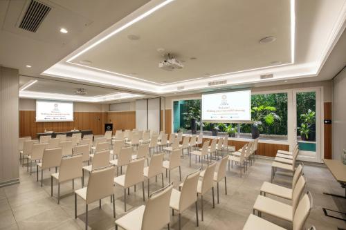 a conference room with rows of chairs and screens at Hotel St Martin by OMNIA hotels in Rome