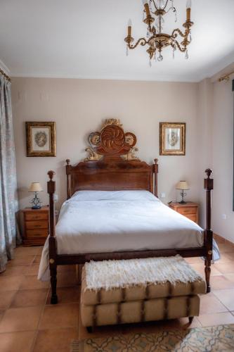a bedroom with a large bed and a chandelier at Finca Orate in Mairena del Alcor
