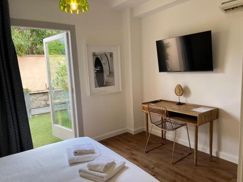une chambre avec un lit, un bureau et une fenêtre dans l'établissement Maison d' Orange - Chambres, à Saint-Tropez