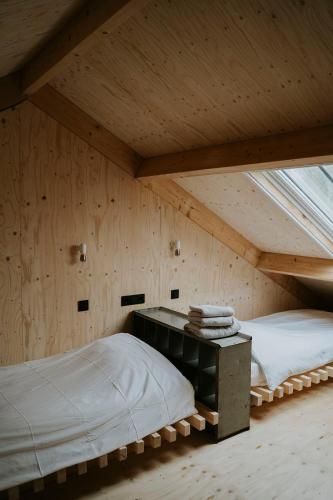 a room with two beds and a desk in a attic at Bed en Brood in de Kapschuur - Boerderij de ZuiderKRIB in Kraggenburg