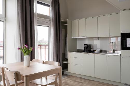 a kitchen with white cabinets and a table at Waterfront Cabins in Gothenburg