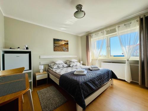 a bedroom with a bed and a large window at Willa Medom in Władysławowo