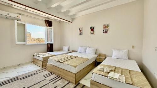 two beds in a room with a window at Casa Del Sol deluxe in Cairo