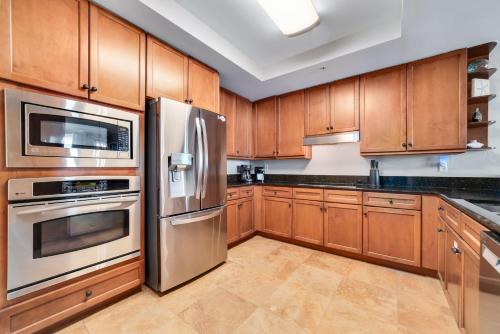 una cucina con armadietti in legno ed elettrodomestici in acciaio inossidabile di Indigo Unit 503W a Pensacola