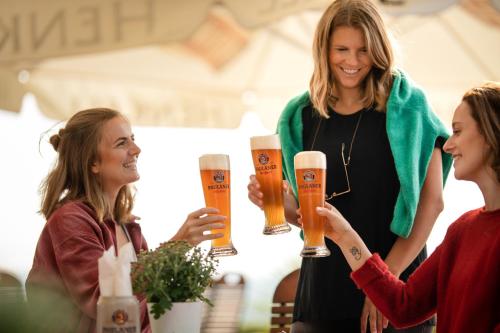 a woman holding two glasses of beer at FAVORITE Parkhotel in Mainz