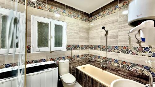 a bathroom with a tub and a toilet and a sink at Casa Del Sol deluxe in Cairo