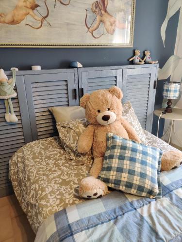 a teddy bear sitting on top of a bed at B&B LE GRETTE in Gioia dei Marsi