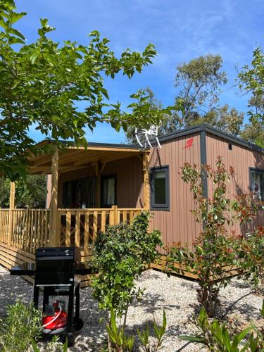 a tiny house with a porch and a deck at Location du Ranch in Algajola
