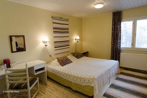 KortteinenにあるViljamaan kartanoのベッドルーム1室(ベッド1台、デスク、窓付)