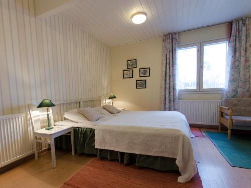 a bedroom with a bed and a table and a window at Viljamaan kartano in Kortteinen
