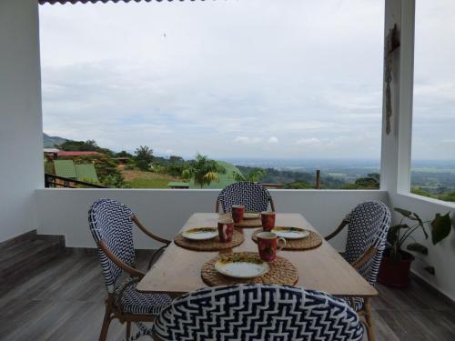 a table and chairs on a balcony with a view at Nido Acacias Cabaña romántica con jacuzzi Azulejo in Acacías