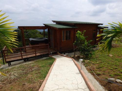 a small cabin with a bench and a porch at Nido Acacias Cabaña romántica con jacuzzi Azulejo in Acacías