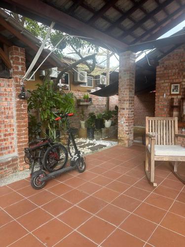 a scooter parked on a patio with a bench at Lelangit Inn in Port Dickson
