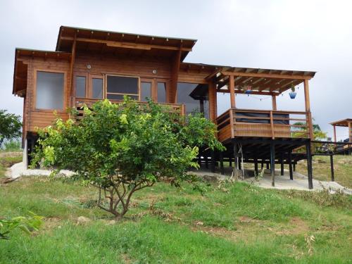 a wooden house with a porch and a deck at Nido Acacias Cabaña romántica con jacuzzi Azulejo in Acacías