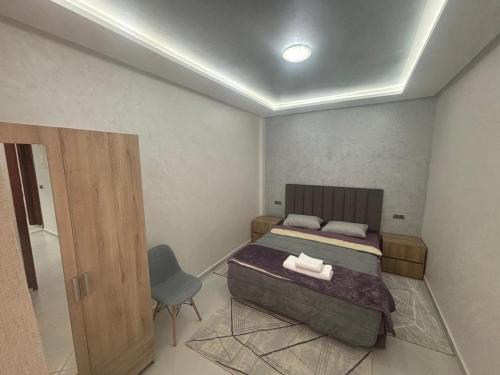 a bedroom with a bed and a chair in it at appartement agadir in Agadir