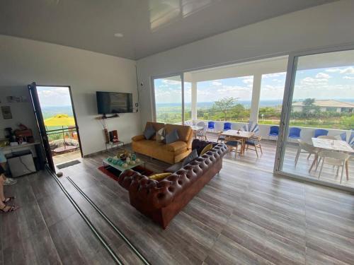 a living room with a leather couch and a table at Nido Acacias Cabaña romántica con jacuzzi Azulejo in Acacías