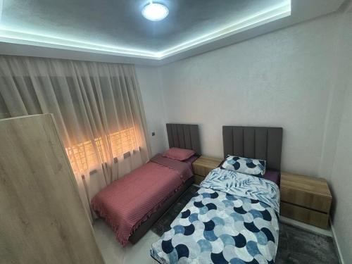a bedroom with two beds and a window at appartement agadir in Agadir