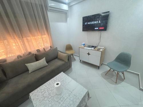 a living room with a couch and a tv at appartement agadir in Agadir