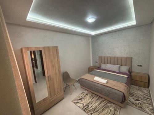 a small bedroom with a bed and a mirror at appartement agadir in Agadir