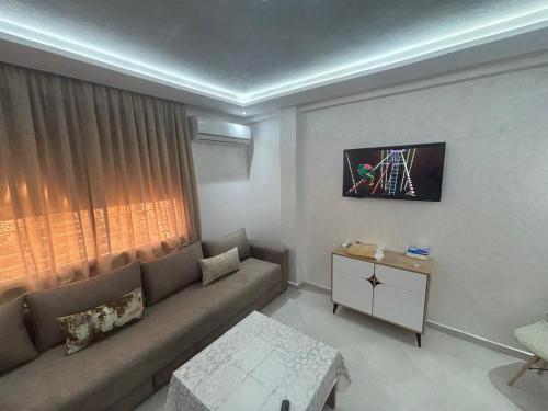 a living room with a couch and a window at appartement agadir in Agadir