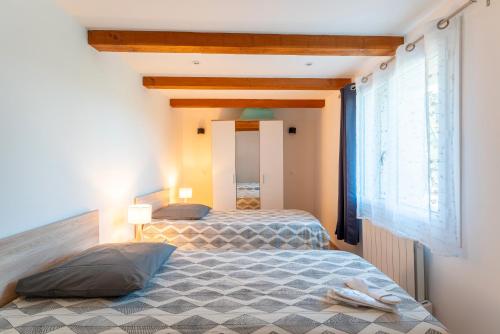 a bedroom with two beds and a window at Appartement Campagne in Avignon
