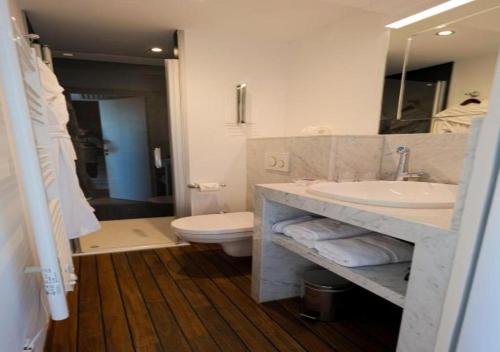 a bathroom with a sink and a toilet at Hôtel Merveilleux Côté Mer in Dunkerque