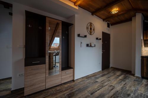a living room with wooden floors and a clock on the wall at Agape Apartments in Kotor