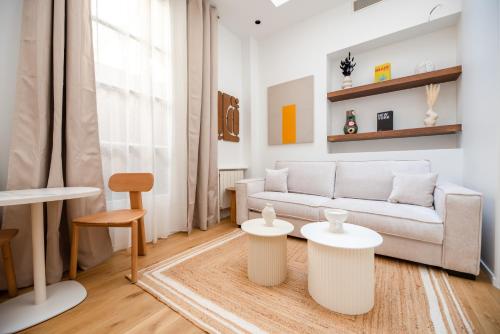 un salon avec un canapé et deux tables dans l'établissement CIA - Elegant Flat Sentier, Grands Boulevards, à Paris