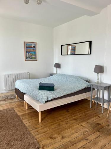 a bedroom with a bed and a table and two lamps at Lovely Normandy - Appt en centre ville de Bayeux in Bayeux