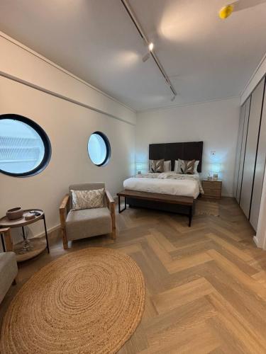 ケープタウンにあるCity Centre Studio with Pool at Zeeland Pier - 902のベッドと椅子と2つの窓がある寝室