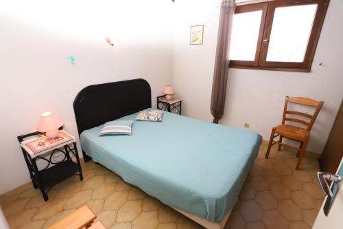 - une petite chambre avec un lit bleu et une chaise dans l'établissement Maison climatisée avec terrasse à st Cyprien, à Saint-Cyprien