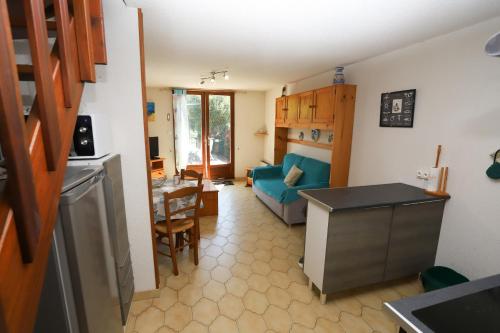 Il comprend une cuisine et un salon avec un canapé bleu. dans l'établissement Maison climatisée avec terrasse à st Cyprien, à Saint-Cyprien