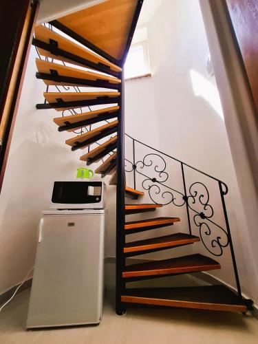 a spiral staircase with wood and wrought iron railing at Penzion PANDA Tourist in Turčianske Teplice