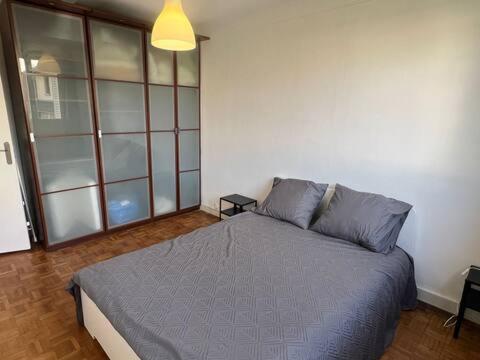 une chambre avec un grand lit dans une pièce dans l'établissement Joli appartement à Montreuil, proche des nouvelles stations de métro, à Montreuil