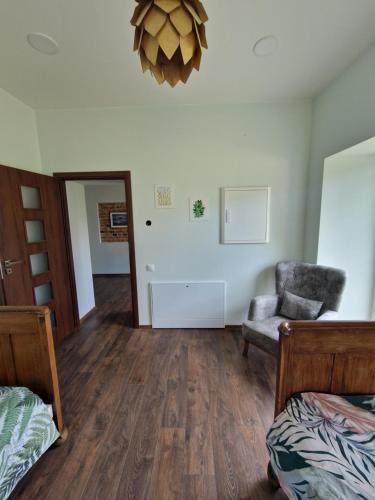 a bedroom with a bed and a chair and a mirror at Laumės dvaras in Kruopinė