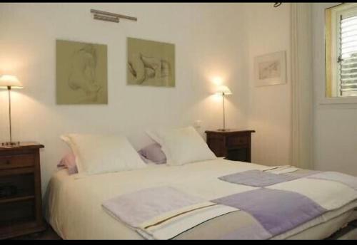 une chambre avec un grand lit blanc avec deux tables de nuit dans l'établissement Villa Ysee, à Porto-Vecchio