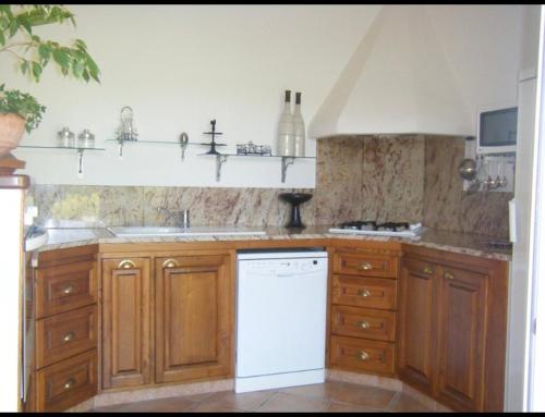 - une cuisine avec des placards en bois et un lave-vaisselle blanc dans l'établissement Villa Ysee, à Porto-Vecchio
