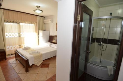 a bedroom with a bed and a shower and a tub at Martiniuc Smart House 2 in Costinesti