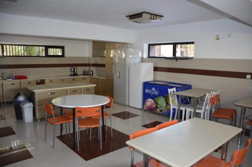 a kitchen with tables and chairs and a refrigerator at Martiniuc Smart House 2 in Costinesti
