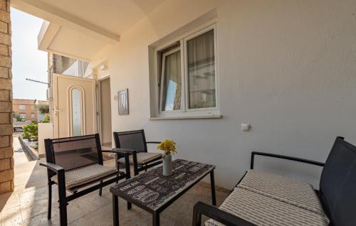a patio with chairs and a table and a window at Gorgeous Apartment In Novalja With Wifi in Novalja