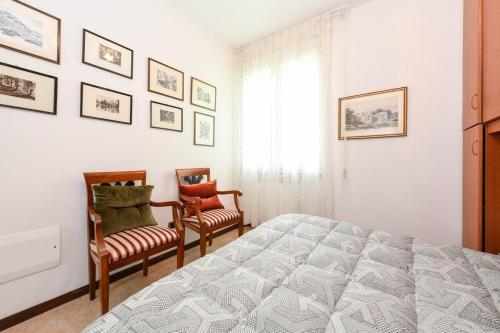 a bedroom with a large bed and two chairs at Villa Emma in Toscolano Maderno
