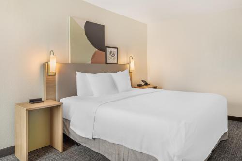a hotel room with a large white bed and two tables at Spark by Hilton Knoxville North I-75 in Knoxville